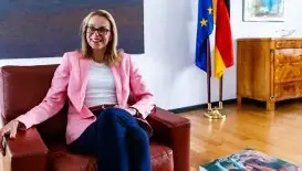 Maria gosse es la nueva embajadora. ella es sentado en una silla en su oficina.